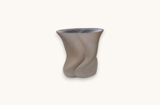 Ceramic vase with wavy design on a white background